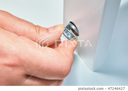 handyman fixes cam lock nut, furniture assembly. handyman fixes cam lock nut, furniture assembly. 47246427