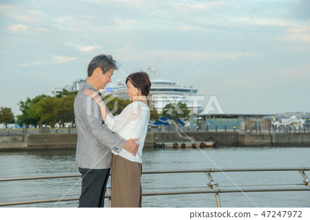 Married Couple Travel-around the Nose Park of Yokohama large cruise ship statue at dusk 47247972
