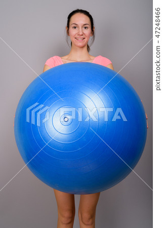 Young beautiful woman ready for gym holding exercise ball Young beautiful woman ready for gym holding exercise ball 47248466