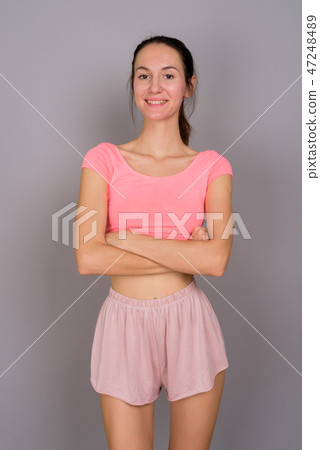 Young beautiful woman ready for gym against gray background 47248489
