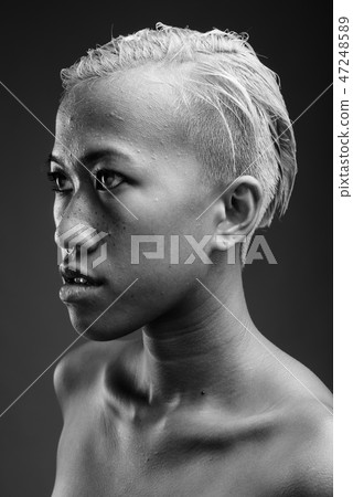Young beautiful rebellious woman with short hair against gray ba 47248589