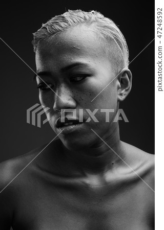 Young beautiful rebellious woman with short hair against gray ba 47248592
