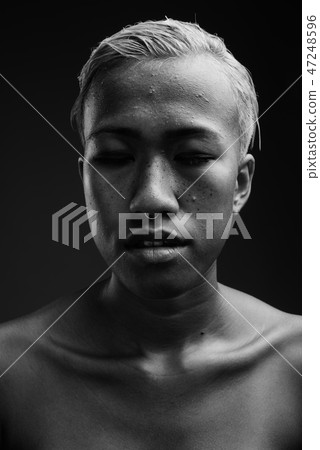 Young beautiful rebellious woman with short hair against gray ba 47248596