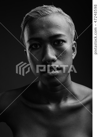 Young beautiful rebellious woman with short hair against gray ba 47248598