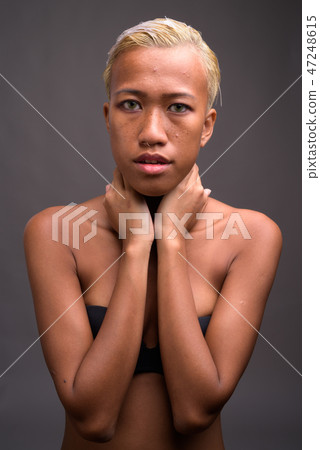 Young beautiful rebellious woman with short hair against gray ba Young beautiful rebellious woman with short hair against gray ba 47248615