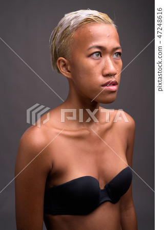 Young beautiful rebellious woman with short hair against gray ba 47248616