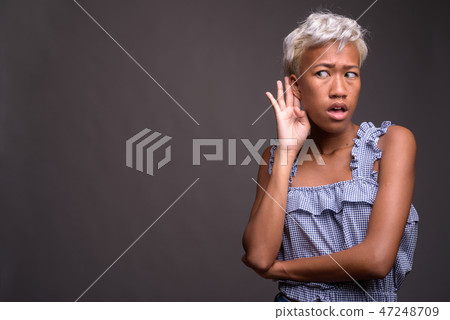 Young beautiful rebellious woman with short hair listening 47248709