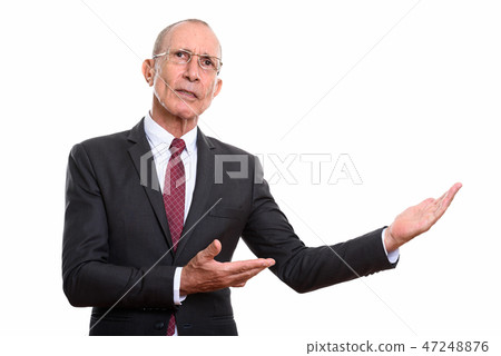 Studio shot of senior businessman showing something Studio shot of senior businessman showing something 47248876