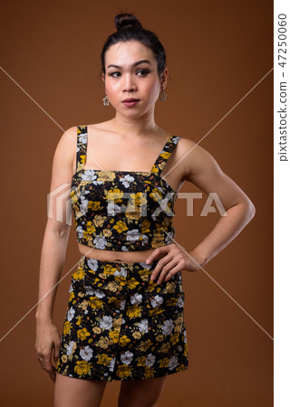 Young beautiful Asian transgender woman against brown background Young beautiful Asian transgender woman against brown background 47250060