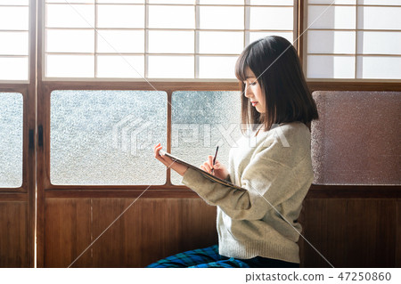 A young woman sketching in an old private house 47250860