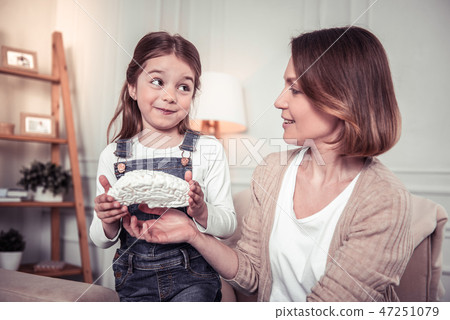 Cute delighted girl holding a brain model Cute delighted girl holding a brain model 47251079