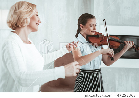 Positive nice girl practicing her music skills 47252363