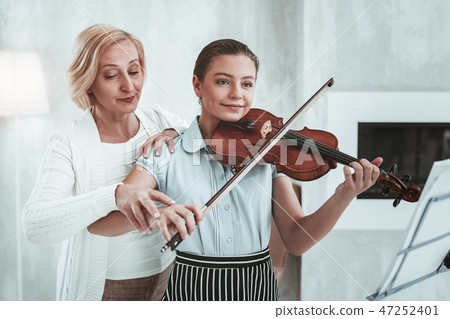 Nice aged woman standing behind her student 47252401