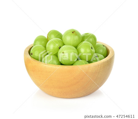 Indian gooseberry in wooden bowl white background Indian gooseberry in wooden bowl white background 47254611