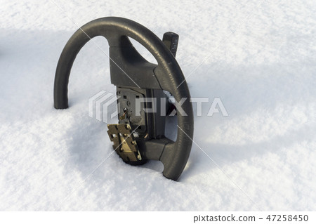 Steering wheel without airbag half buried in snow Steering wheel without airbag half buried in snow 47258450