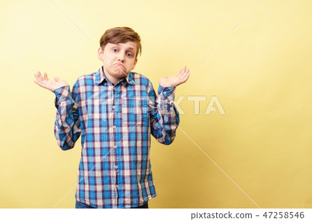 I don't know. clueless boy lifts hands in dismay  47258546
