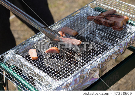 Men baking bacon at barbecue 47258609