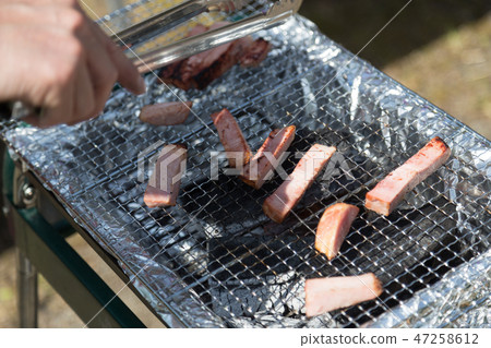 Men baking bacon at barbecue 47258612
