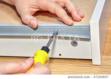 Assemble furniture, screwed screw with screwdriver Assemble furniture, screwed screw with screwdriver 47260607