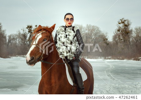 Fashionable woman riding a horse. Fashionable woman riding a horse. 47262461