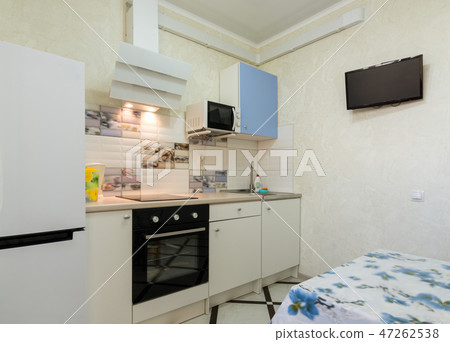 The interior of a small kitchen with a TV on 47262538