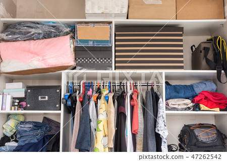 Open wardrobe with things and boxes in  47262542