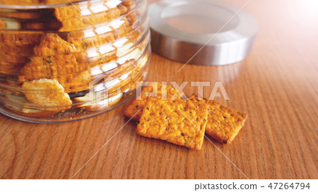 Wheat cracker in a glass jar on wooden table. Wheat cracker in a glass jar on wooden table. 47264794