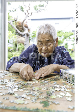 Grandma playing jigsaw puzzle 47264926