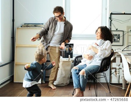 Happy young family laughing and dancing at home Happy young family laughing and dancing at home 47265688