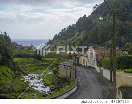 Road in old small village Faial da Terra with cascading river and sea horizon, Sao Miguel, Azores Road in old small village Faial da Terra with cascading river and sea horizon, Sao Miguel, Azores 47267983