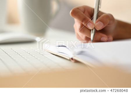 Female hand holding silver pen ready to make Female hand holding silver pen ready to make 47268048