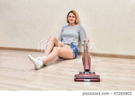 cleaning dust with cordless handheld vacuum. 47268903