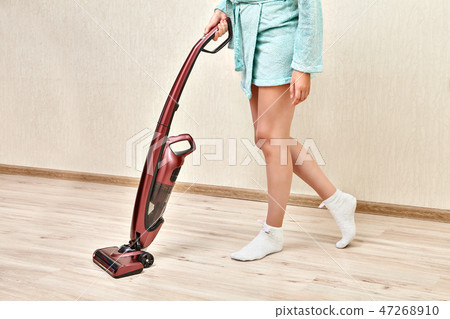 Woman with handheld vacuum cleaner in  hands. 47268910