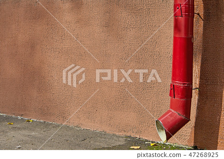 Roof gutter drainpipe of red color on house facade Roof gutter drainpipe of red color on house facade 47268925