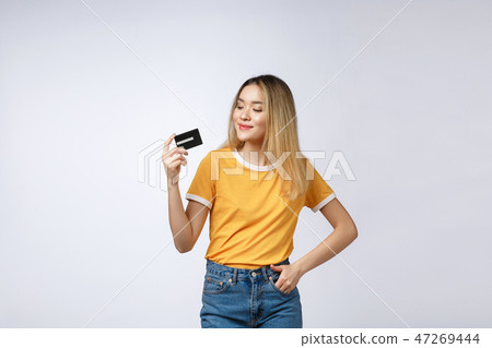 Asian content woman holding fan of money dollar banknotes and credit card and looking on copyspace Asian content woman holding fan of money dollar banknotes and credit card and looking on copyspace 47269444