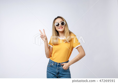 Young asian woman wearing sunglasses over isolated background showing and pointing up with fingers Young asian woman wearing sunglasses over isolated background showing and pointing up with fingers 47269591
