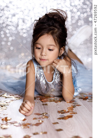 little girl in blue dress sitting on the floor with confetti little girl in blue dress sitting on the floor with confetti 47269592