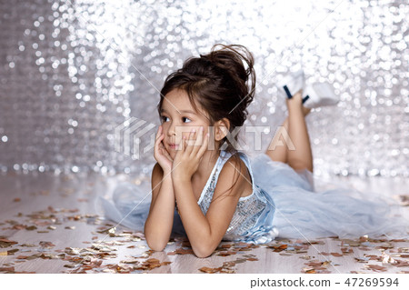 little girl in blue dress sitting on the floor with confetti little girl in blue dress sitting on the floor with confetti 47269594