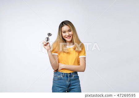Young happy Asian woman smiling in fashionable dress and sunglasses and summer hat over Young happy Asian woman smiling in fashionable dress and sunglasses and summer hat over 47269595
