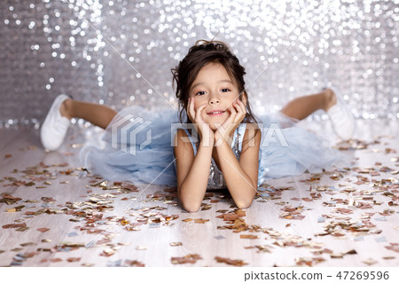 little girl in blue dress sitting on the floor with confetti little girl in blue dress sitting on the floor with confetti 47269596