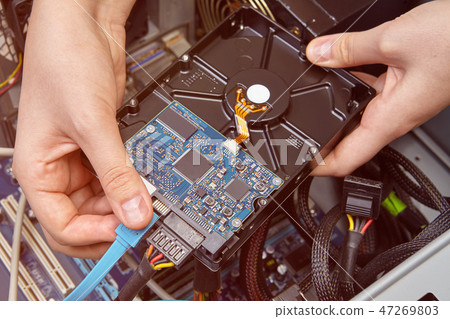 Plugging in data cable into SATA conectors. Plugging in data cable into SATA conectors. 47269803