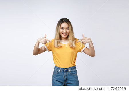 Asian woman pointing finger to her shirt isolate over grey background. Asian woman pointing finger to her shirt isolate over grey background. 47269919
