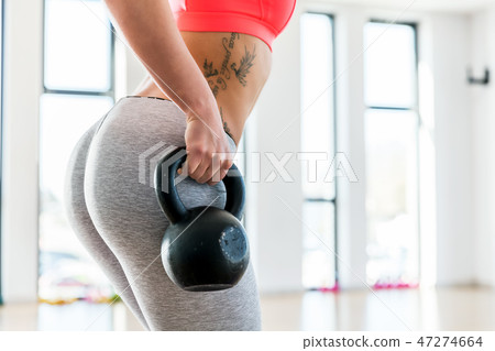 Fit woman holding a kettlebell. 47274664