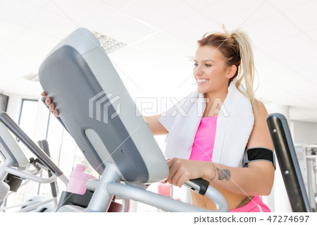 Young woman starts treadmill running. 47274697