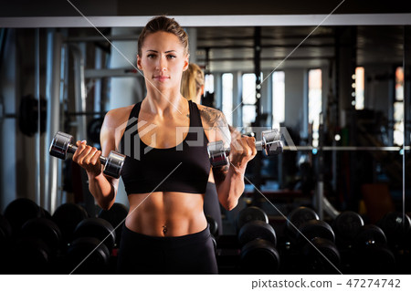 Attractive woman exercising at the gym. 47274742