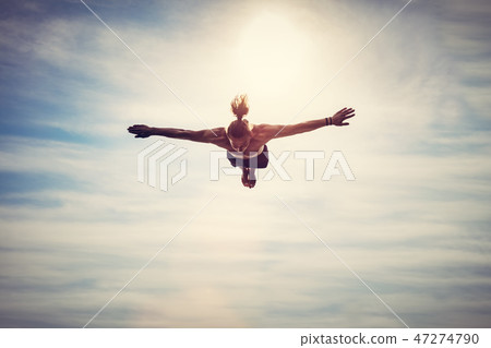 Young man flying in the sky. 47274790