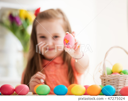 Young girl showing drawing on an egg. Young girl showing drawing on an egg. 47275024