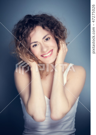 Attractive young woman touching her hair and face. 47275026
