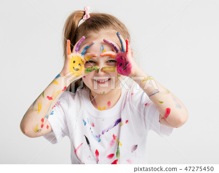 Little girl covered in paint making funny faces. Little girl covered in paint making funny faces. 47275450