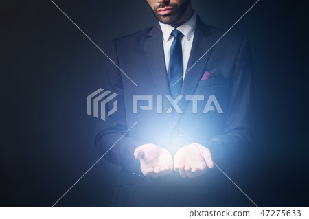 Light radiating from businessman hands Light radiating from businessman hands 47275633